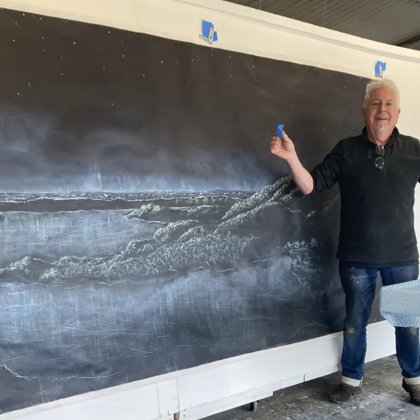 Ben with his artwork depicting Tower Hill under a starry night sky 
