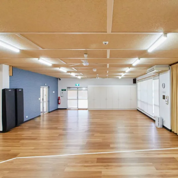 The recreation room at Archie Graham is a large, open space with polished floorboards.