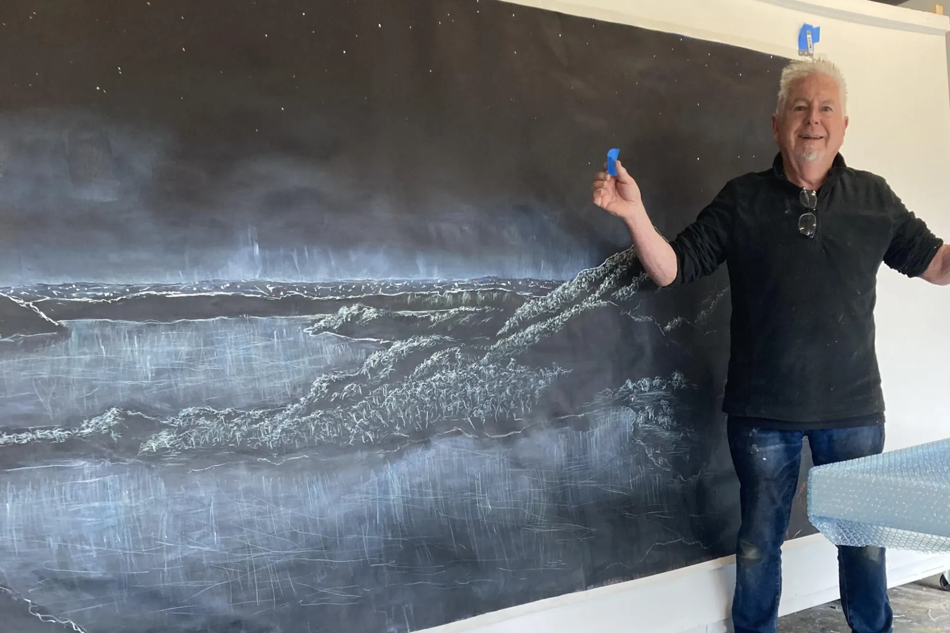 Ben with his artwork depicting Tower Hill under a starry night sky 