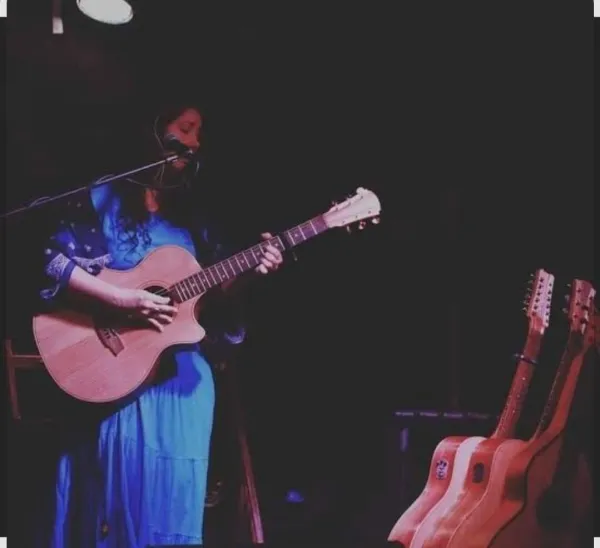 A female singer playing guitar